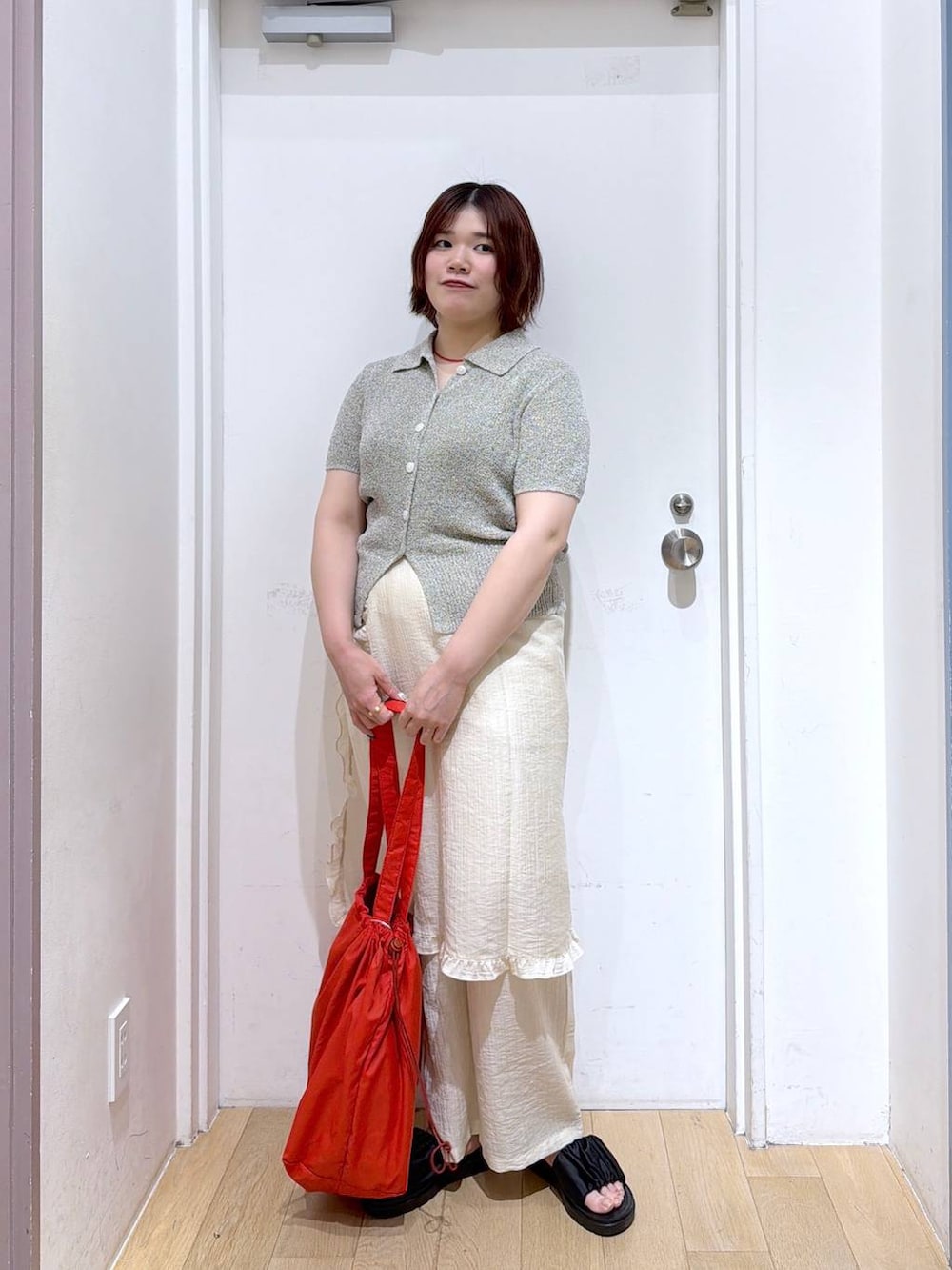 ブラック系のサンダル、グレー系のTシャツ/カットソー、レッド系のショルダーバッグを着用したレディースの春コーディネートの2枚目の写真