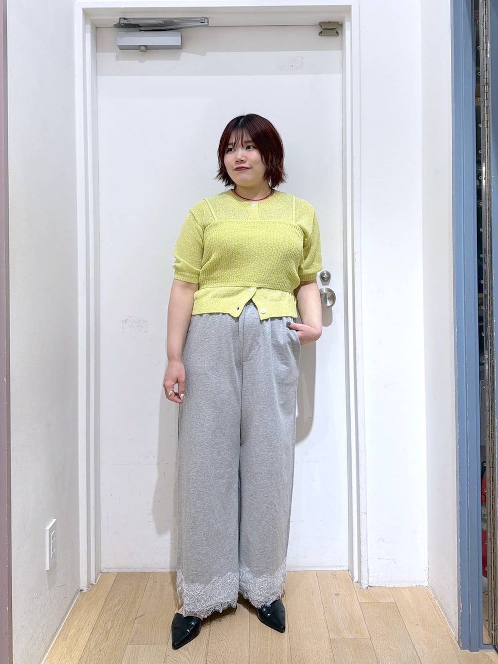ブラック系のサンダル、グレー系のスウェットパンツ、イエロー系のTシャツ/カットソーを着用したレディースの春コーディネートの2枚目の写真
