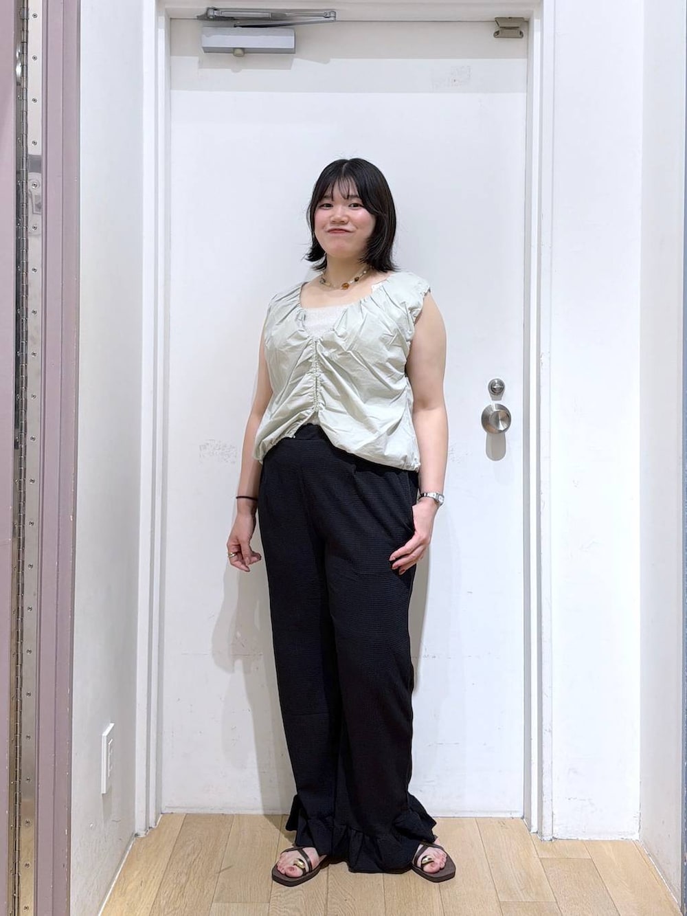 グリーン系のシャツ/ブラウス、シルバー系のタンクトップ、ブラウン系のサンダルを着用したレディースの夏コーディネートの2枚目の写真