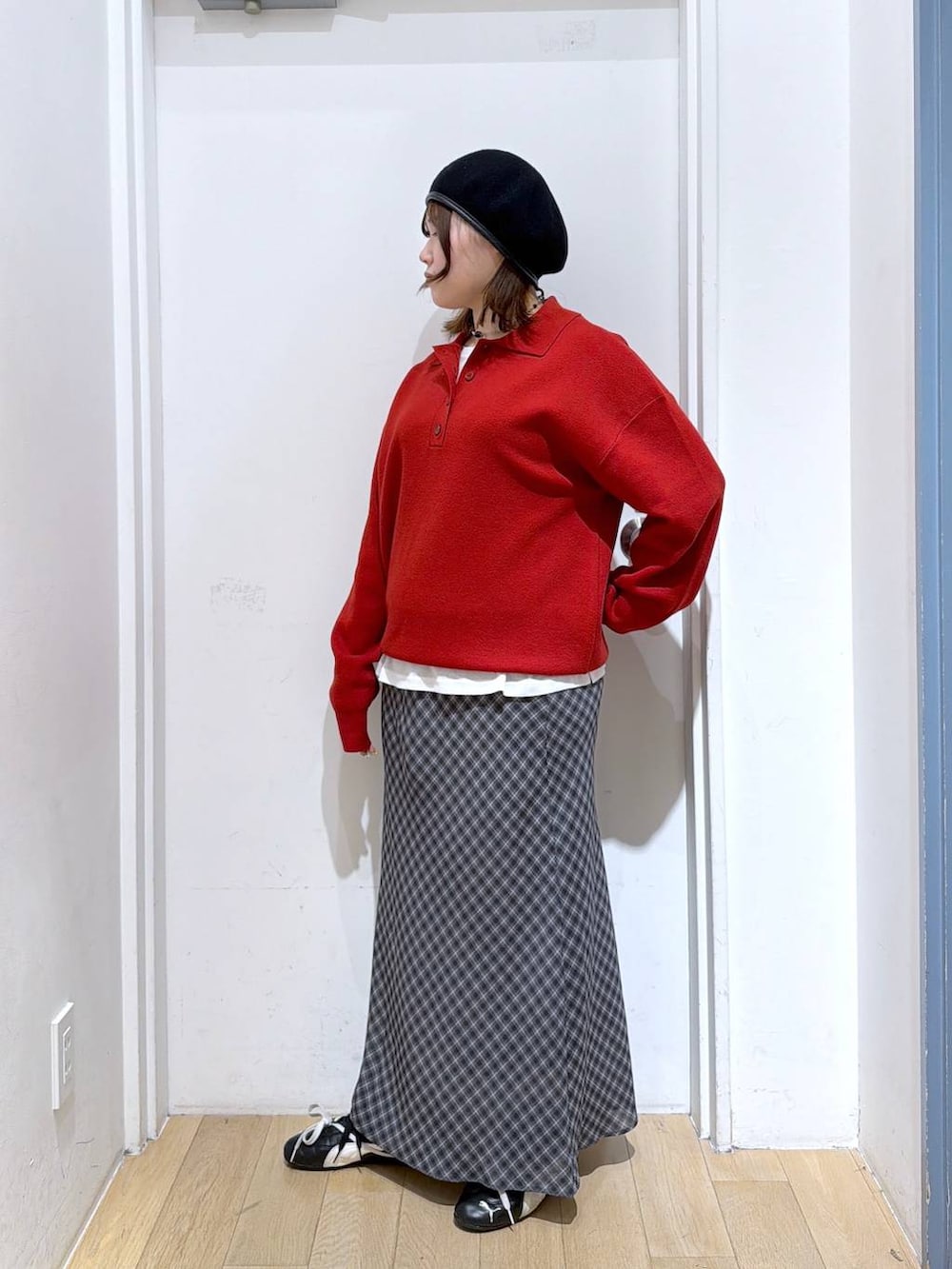 ホワイト系のTシャツ/カットソー、グレー系のスカート、レッド系のニット/セーターを着用したレディースの冬コーディネートの2枚目の写真