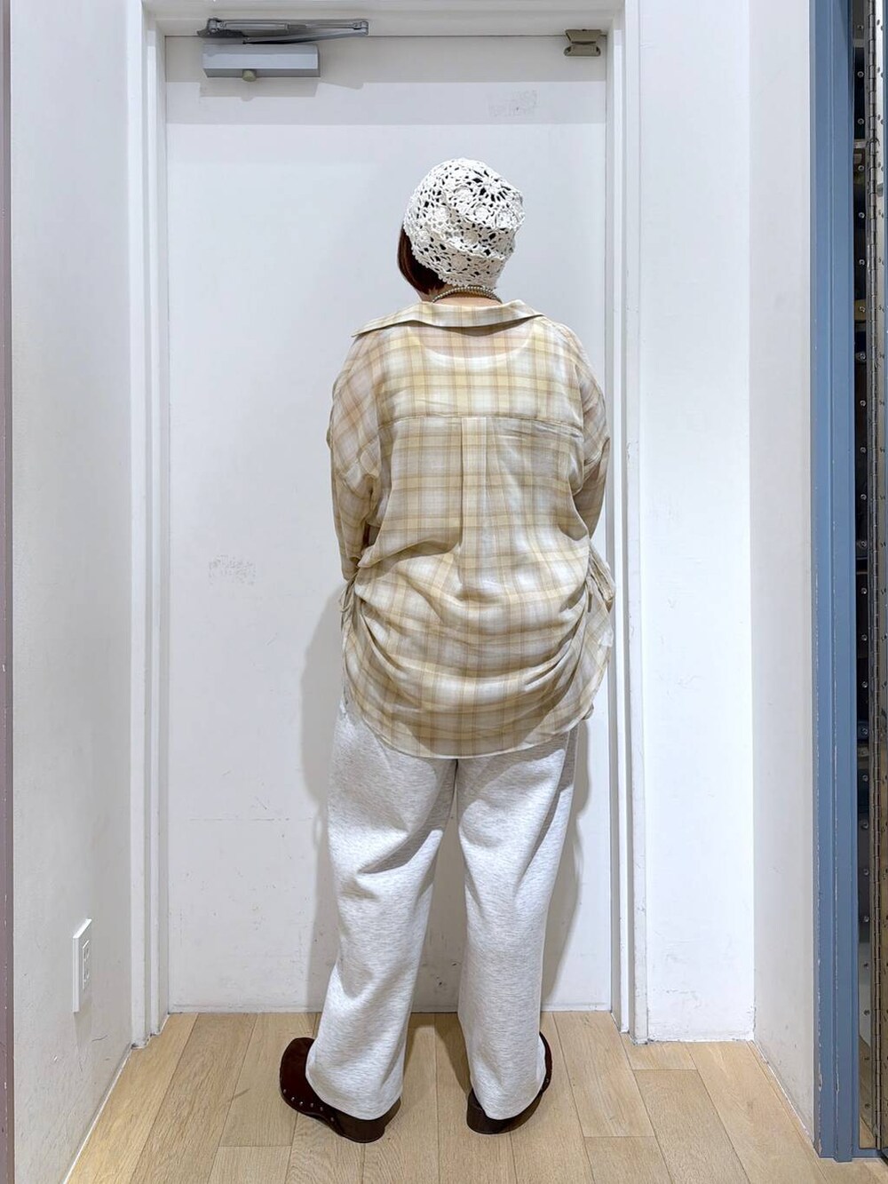 グレー系のスウェットパンツ、ブラウン系のサンダル、ホワイト系のタンクトップを着用したレディースの春コーディネートの4枚目の写真