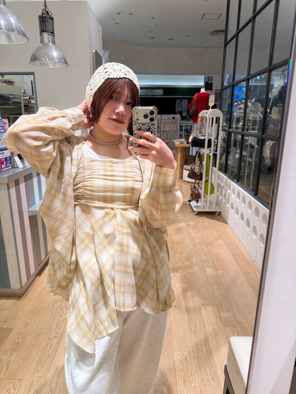 グレー系のスウェットパンツ、ブラウン系のサンダル、ホワイト系のタンクトップを着用したレディースの春コーディネートの5枚目の写真