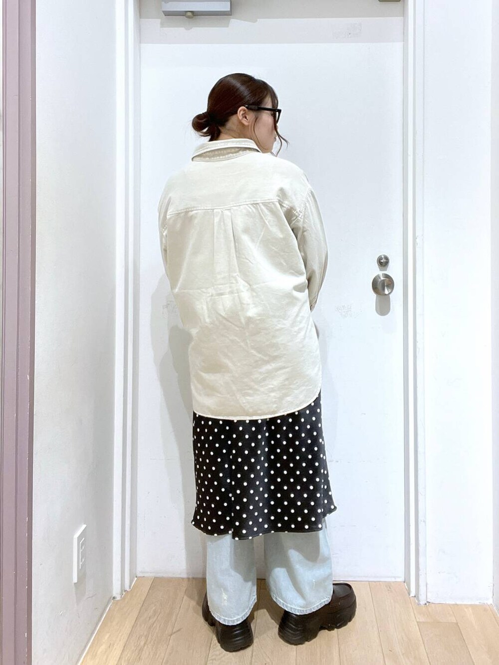 ブラック系のスカート、ベージュ系のシャツ/ブラウス、ブルー系のデニムパンツを着用したレディースの冬コーディネートの3枚目の写真