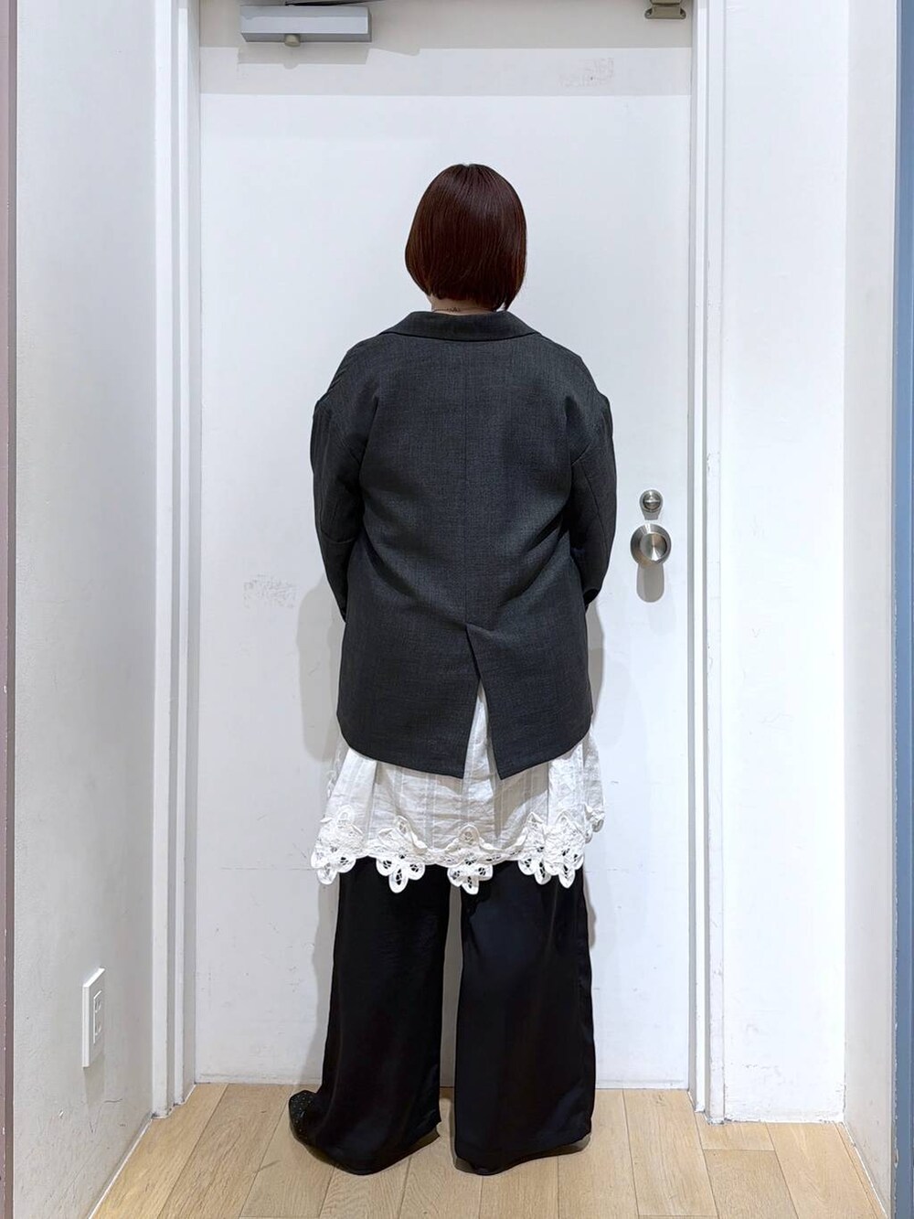 グレー系のテーラードジャケット、ブラック系のその他パンツ、ホワイト系のワンピースを着用したレディースの春コーディネートの4枚目の写真