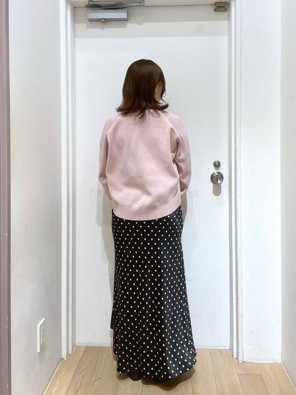 ブラック系のスカート、ブラウン系のトートバッグ、ブラック系のローファーを着用したレディースの冬コーディネートの3枚目の写真