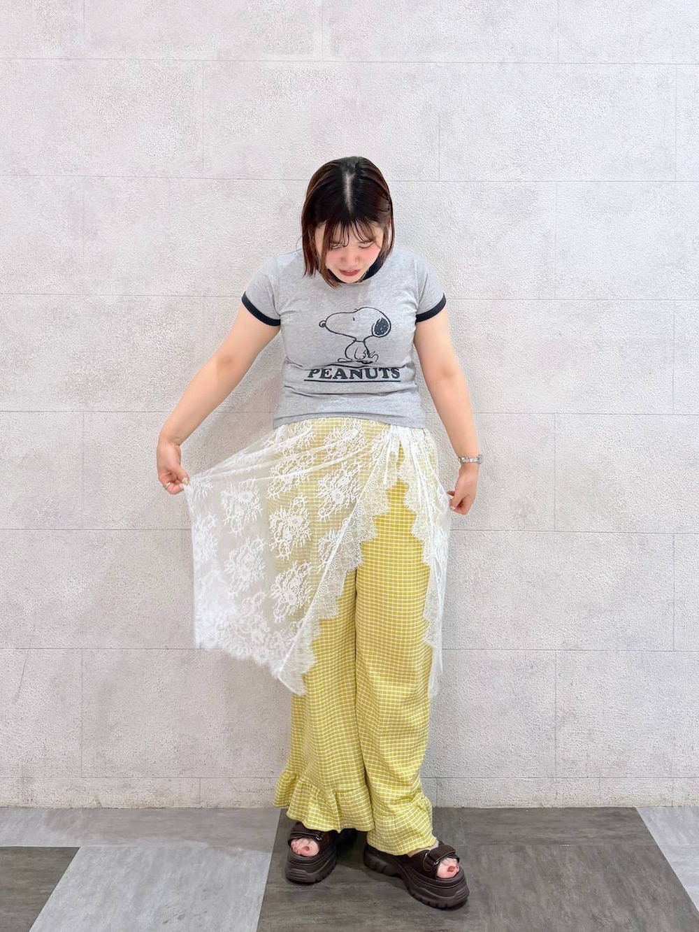 ブラック系のボディバッグ/ウエストポーチ、ホワイト系のサンダル、ブラウン系のTシャツ/カットソーを着用したレディースの夏コーディネートの6枚目の写真
