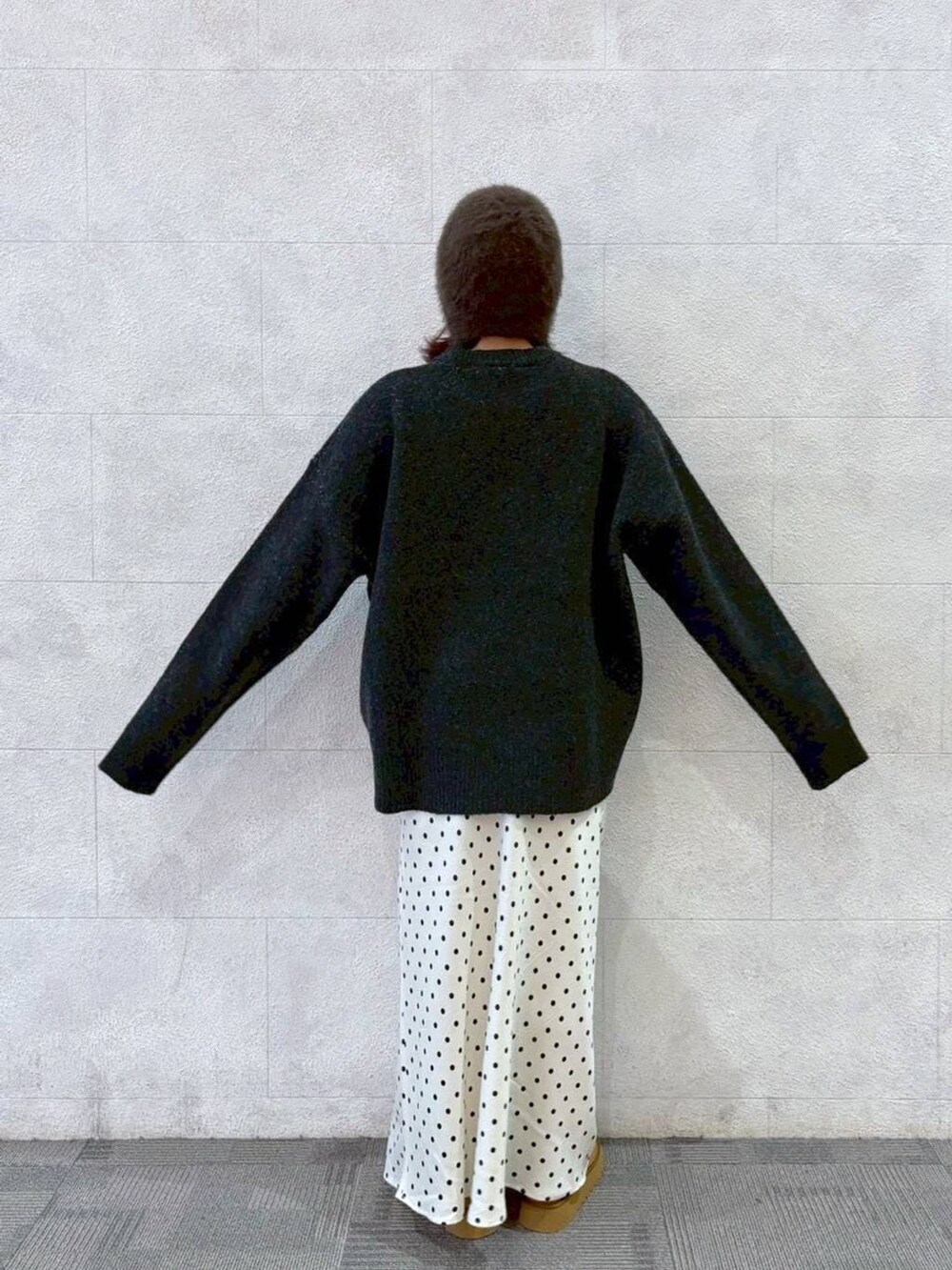 ホワイト系のスカート、ベージュ系のブーツ、グレー系のニット/セーターを着用したレディースの秋コーディネートの3枚目の写真