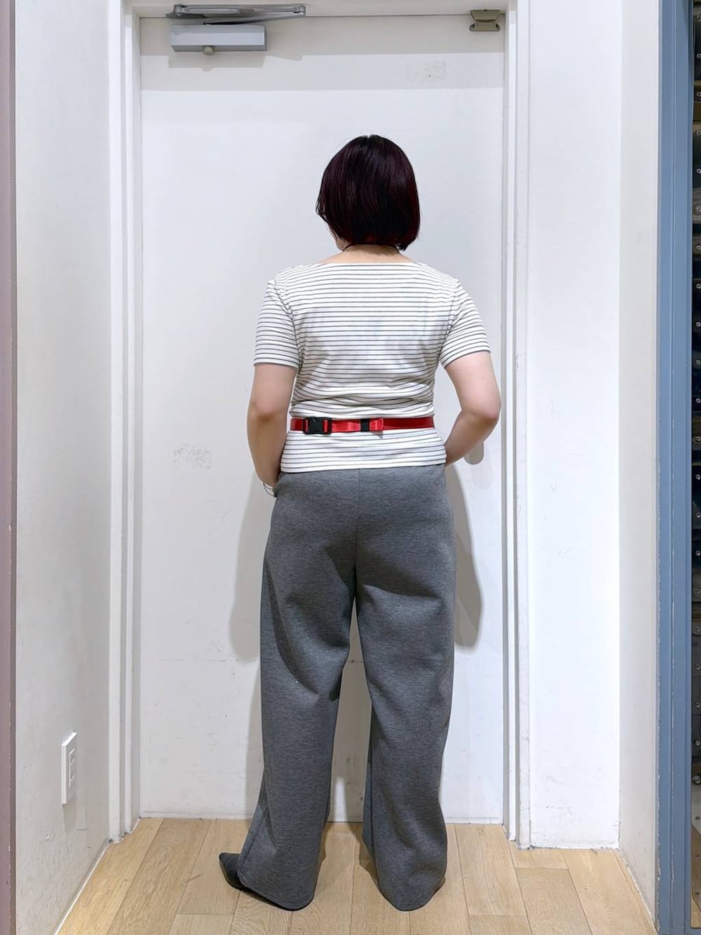グレー系のスウェットパンツ、レッド系のボディバッグ/ウエストポーチ、ホワイト系のTシャツ/カットソーを着用したレディースの春コーディネートの4枚目の写真