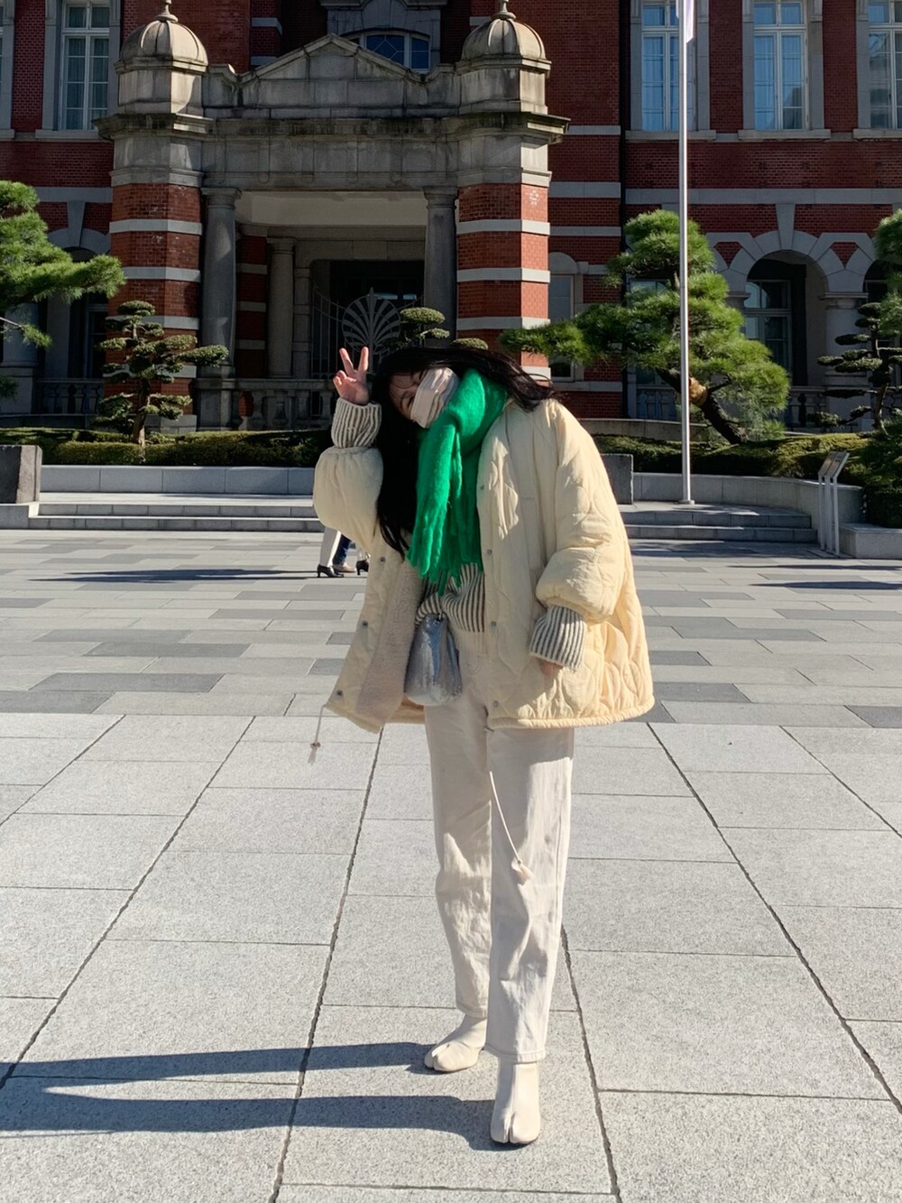 ホワイト系のデニムパンツ、ホワイト系のブーツ、ベージュ系のニット/セーターを着用したレディースの冬コーディネートの2枚目の写真