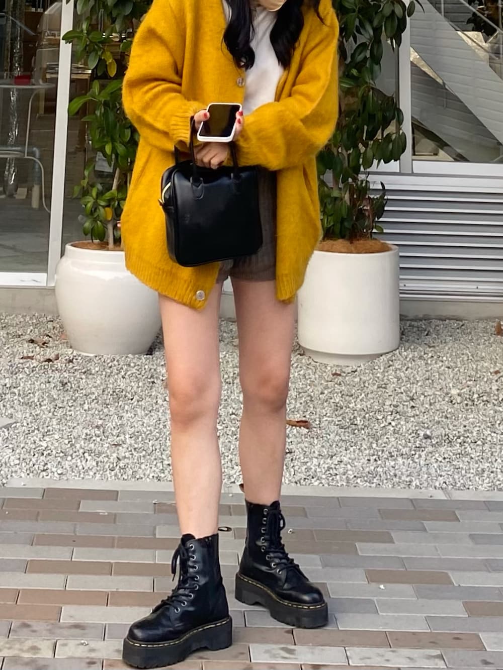 ホワイト系のニット/セーター、ブラック系のショルダーバッグ、イエロー系のカーディガン/ボレロを着用したレディースの秋コーディネートの2枚目の写真