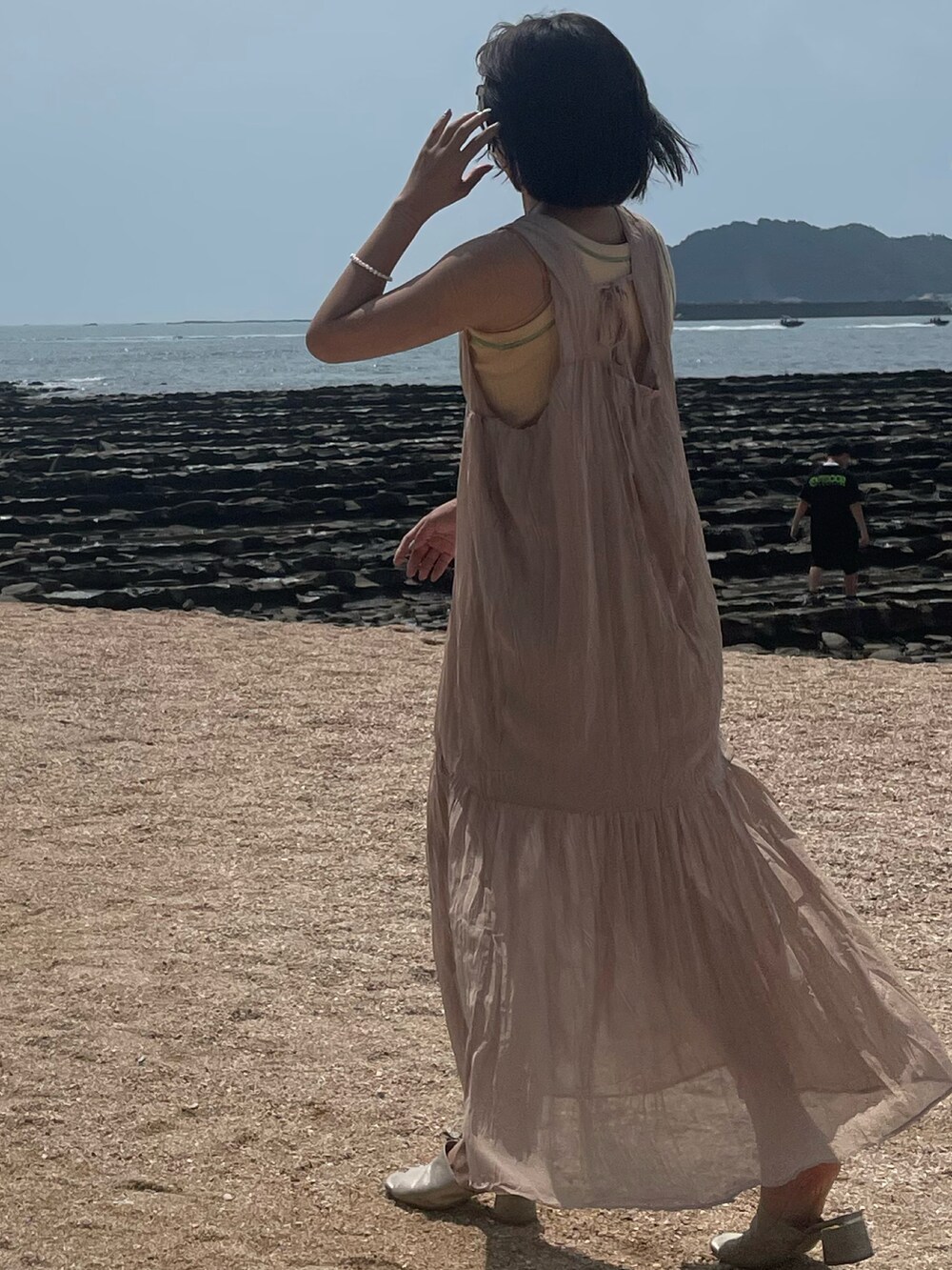 ピンク系のワンピース、オレンジ系のタンクトップを着用したレディースの夏コーディネートの2枚目の写真