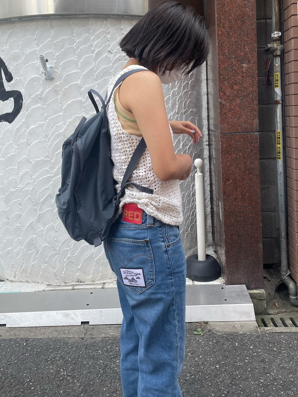 ブルー系のデニムパンツ、ブラック系のスニーカー、ブルー系のバックパック/リュックを着用したレディースの夏コーディネートの2枚目の写真