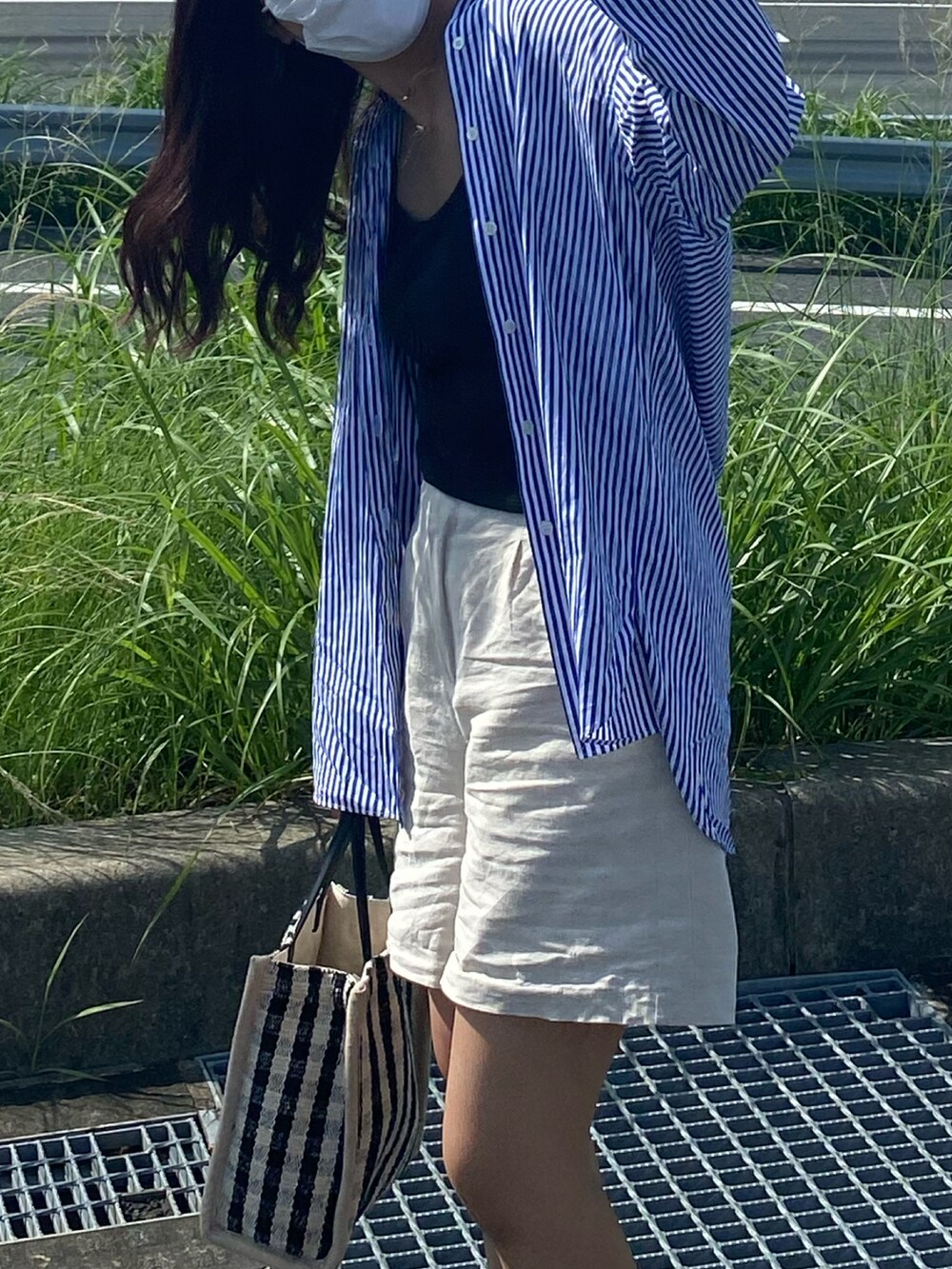 ホワイト系のスニーカー、ブルー系のシャツ/ブラウス、ブラック系のトートバッグを着用したレディースの夏コーディネートの2枚目の写真