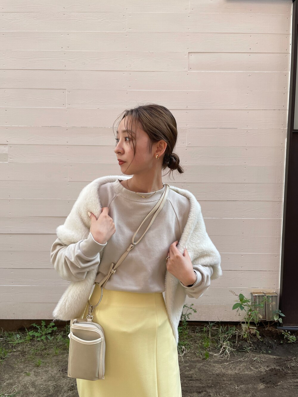 ホワイト系のカーディガン/ボレロ、イエロー系のスカート、グリーン系のブーツを着用したレディースの秋コーディネートの2枚目の写真