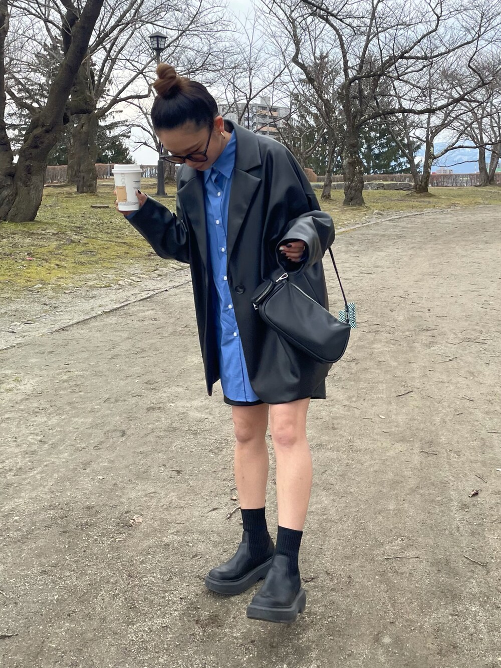 ブラック系のテーラードジャケット、ブルー系のシャツ/ブラウス、ブラック系のその他パンツを着用したレディースの春コーディネートの2枚目の写真