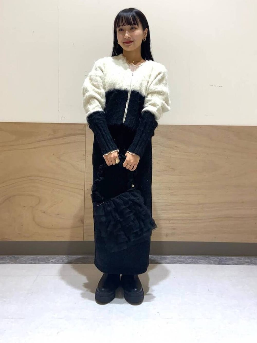 ホワイト系のTシャツ/カットソー、ホワイト系のカーディガン/ボレロ、ブラック系のショルダーバッグを着用したレディースの冬コーディネートの2枚目の写真