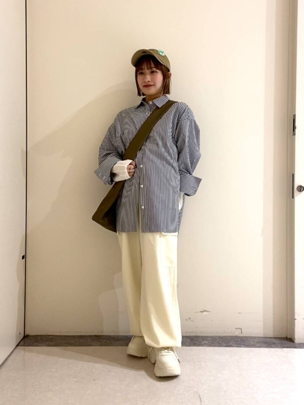 ブラウン系のトートバッグ、ホワイト系のその他パンツ、ホワイト系のスニーカーを着用したレディースの冬コーディネートの2枚目の写真
