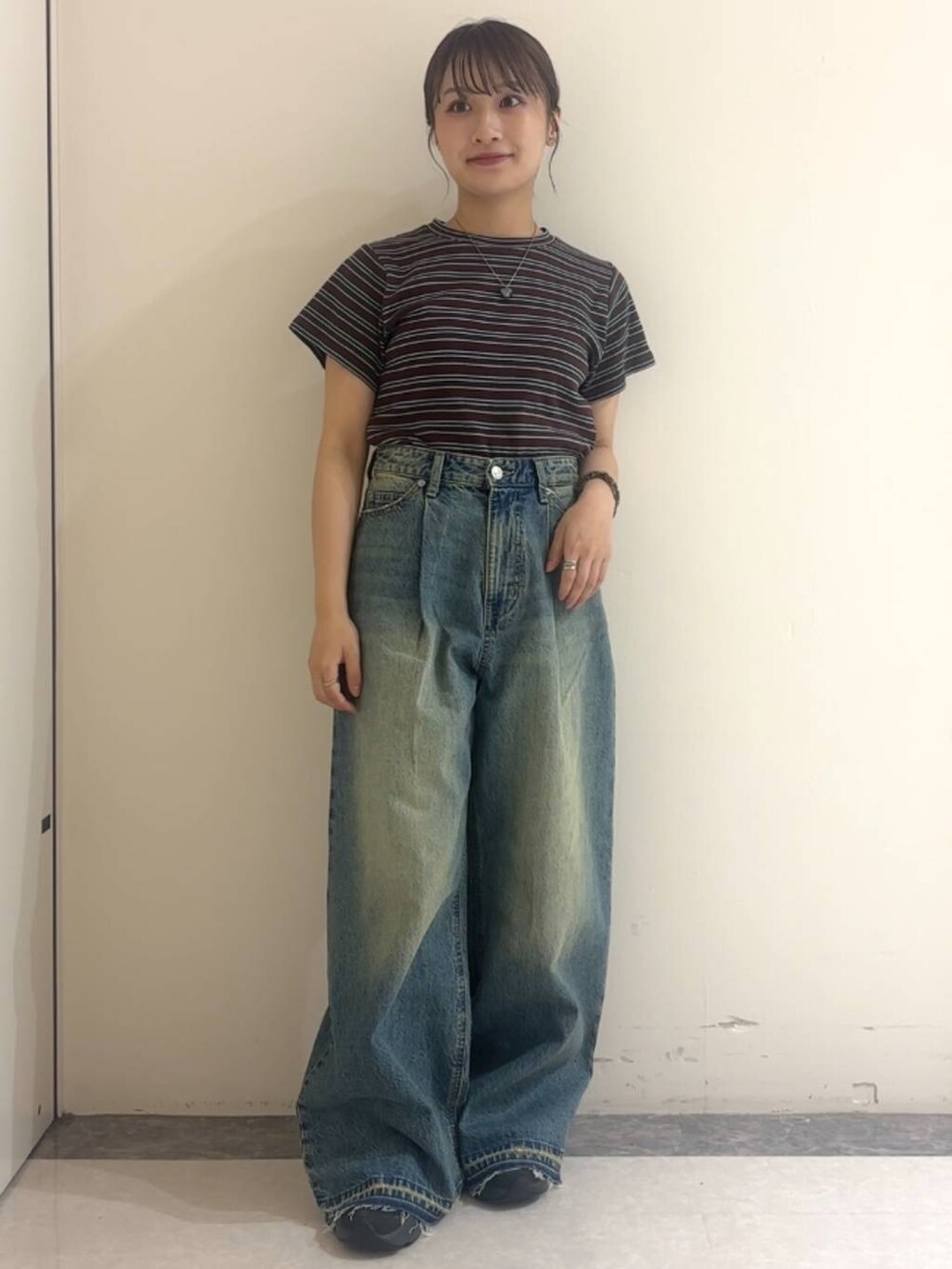 ブラウン系のTシャツ/カットソー、ブルー系のデニムパンツ、ブラック系のネックレスを着用したレディースの夏コーディネートの2枚目の写真