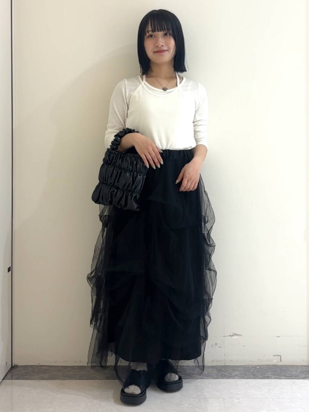 ブラック系のサンダル、ホワイト系のTシャツ/カットソー、ブラック系のショルダーバッグを着用したレディースの春コーディネートの2枚目の写真