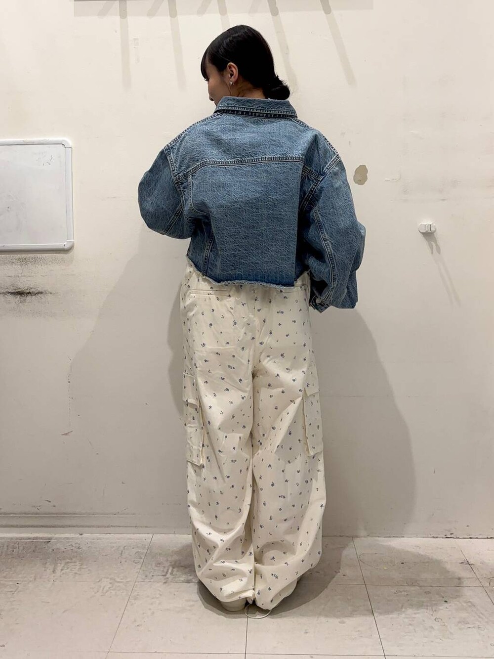 ブルー系のデニムジャケット、ホワイト系のカーゴパンツ、ホワイト系のスニーカーを着用したレディースの春コーディネートの2枚目の写真