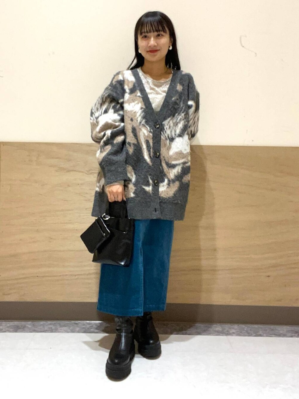 ブラック系のブーツ、ホワイト系のTシャツ/カットソー、ブラック系のショルダーバッグを着用したレディースの冬コーディネートの2枚目の写真