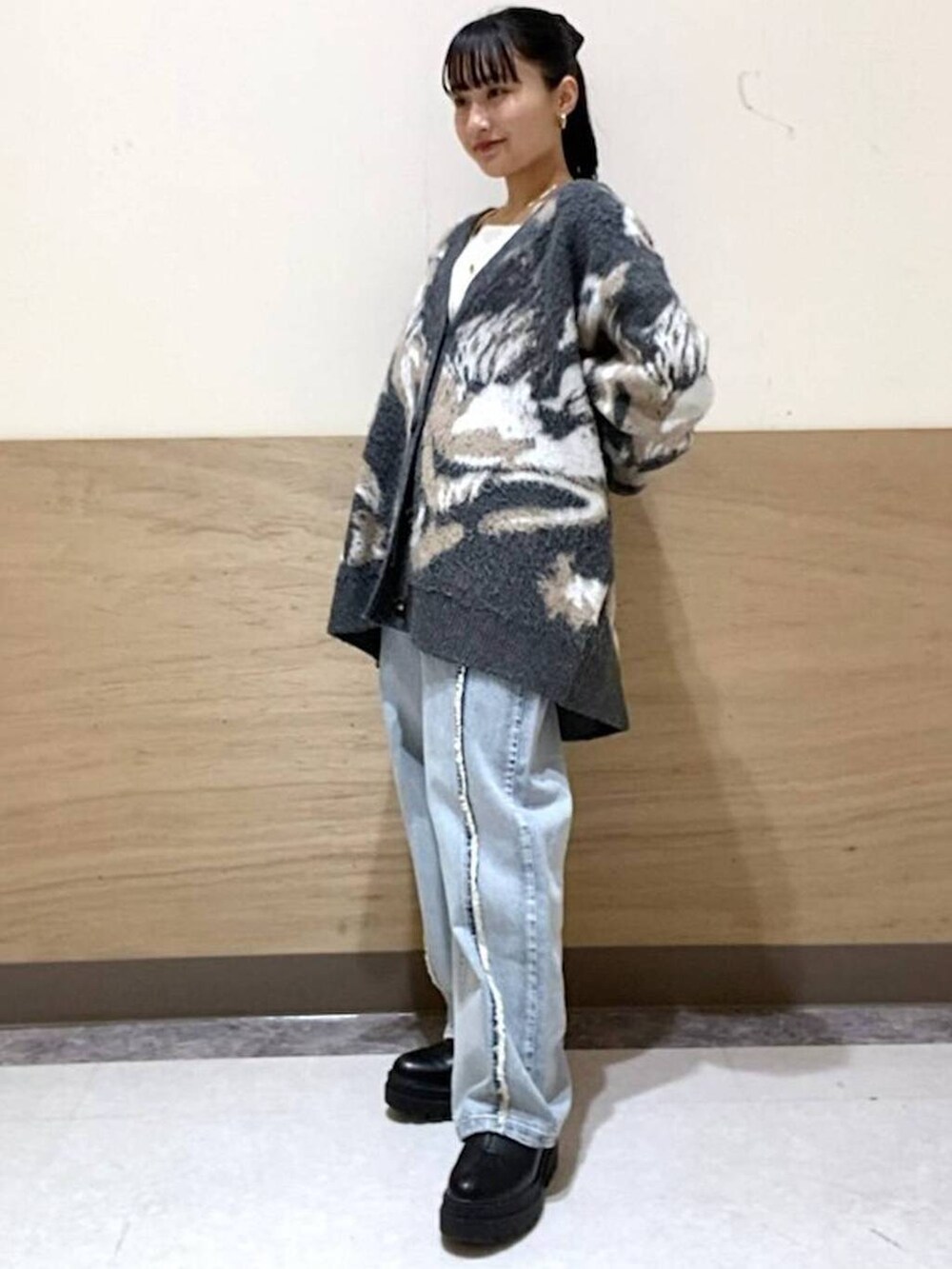 ホワイト系のTシャツ/カットソー、グレー系のカーディガン/ボレロ、ブルー系のデニムパンツを着用したレディースの冬コーディネートの2枚目の写真