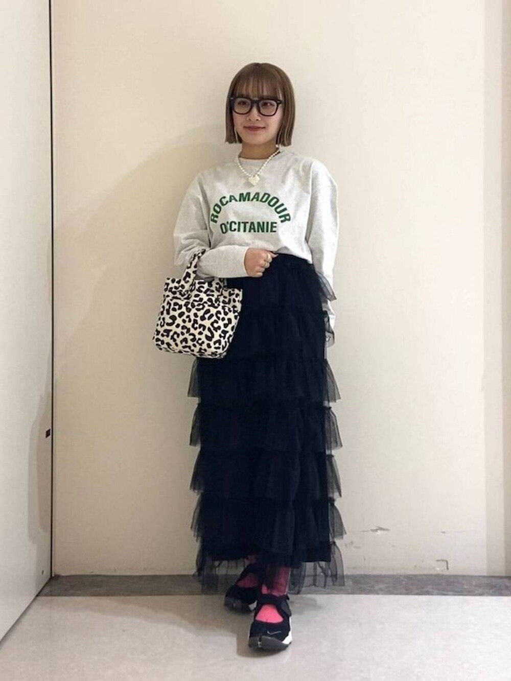 ブラック系のトートバッグ、ブラック系のスカート、グレー系のTシャツ/カットソーを着用したレディースの冬コーディネートの2枚目の写真