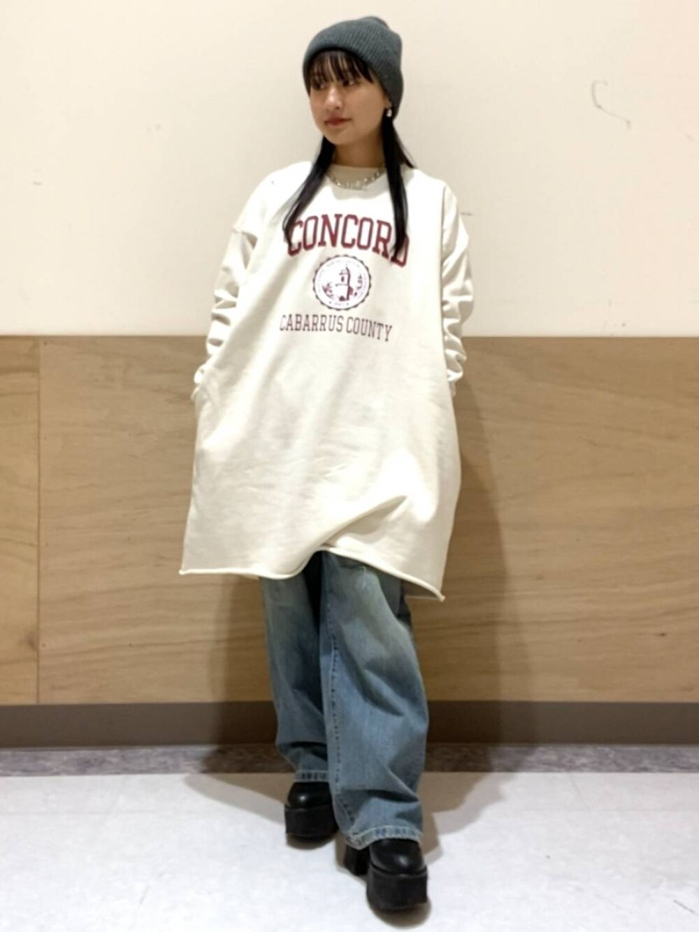 ブルー系のデニムパンツ、ホワイト系のワンピース、シルバー系のネックレスを着用したレディースの冬コーディネートの2枚目の写真