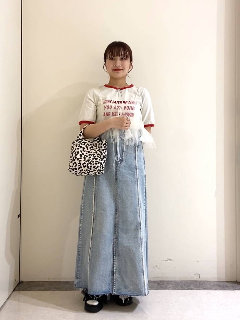 ブラック系のサンダル、ブラック系のトートバッグ、ブルー系のスカートを着用したレディースの春コーディネートの3枚目の写真