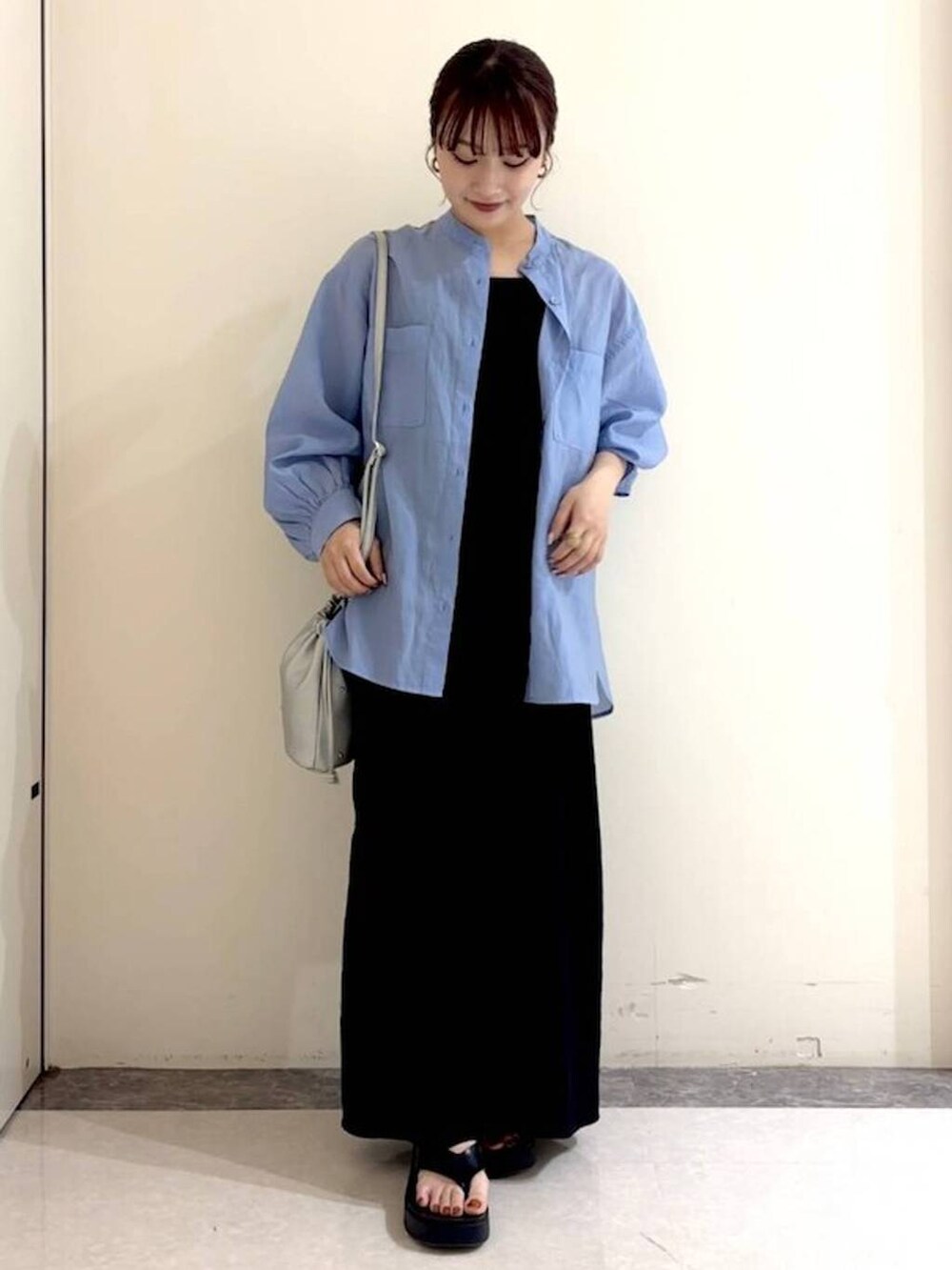 シルバー系のショルダーバッグ、ホワイト系のキャミソール、ブラック系のサンダルを着用したレディースの春コーディネートの2枚目の写真