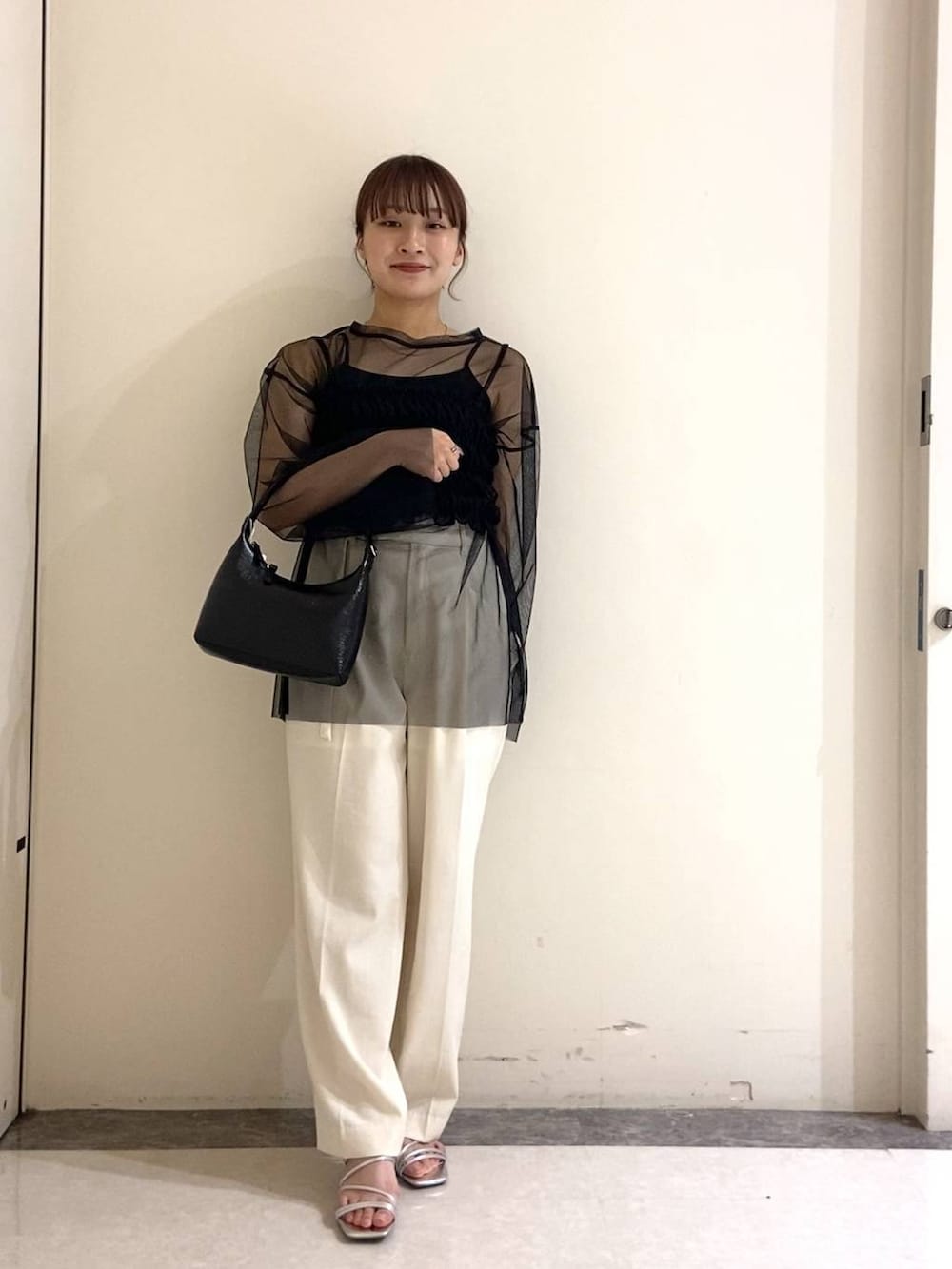 シルバー系のサンダル、ブラック系のTシャツ/カットソー、ブラック系のハンドバッグを着用したレディースの春コーディネートの3枚目の写真