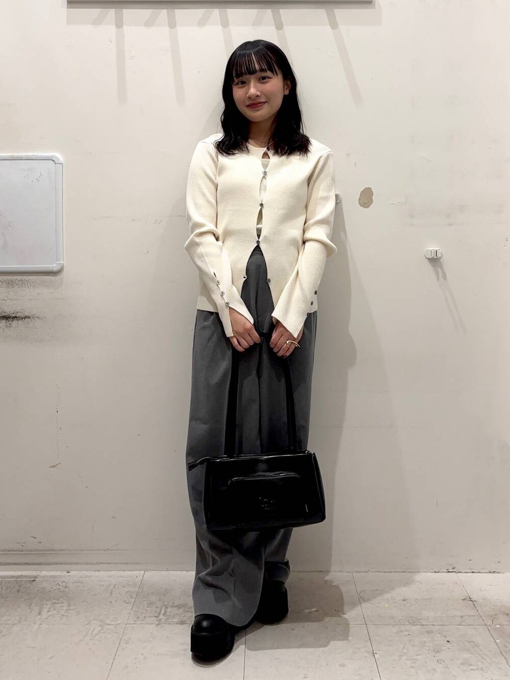 ブラック系のショルダーバッグ、グレー系のその他パンツ、ホワイト系のキャミソールを着用したレディースの冬コーディネートの2枚目の写真