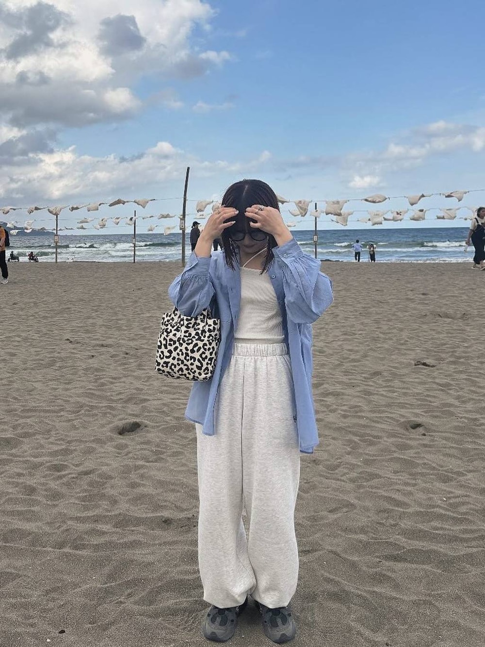 ブラック系のトートバッグ、ベージュ系のスウェットパンツ、ブルー系のシャツ/ブラウスを着用したレディースの春コーディネートの2枚目の写真