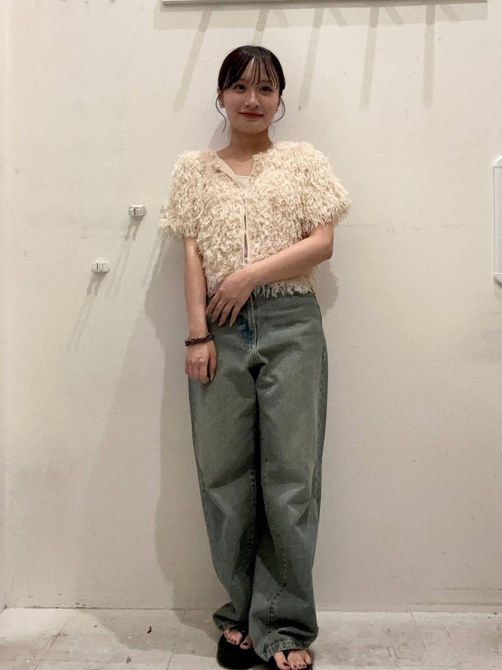 ブルー系のデニムパンツ、ブラック系のサンダル、ホワイト系のキャミソールを着用したレディースの夏コーディネートの3枚目の写真