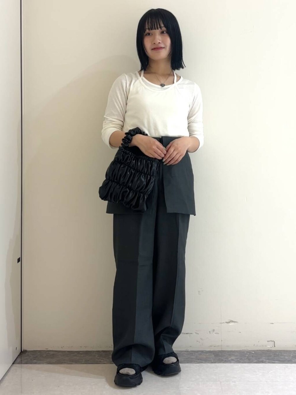 ブラック系のサンダル、ホワイト系のTシャツ/カットソー、グレー系のその他パンツを着用したレディースの春コーディネートの2枚目の写真