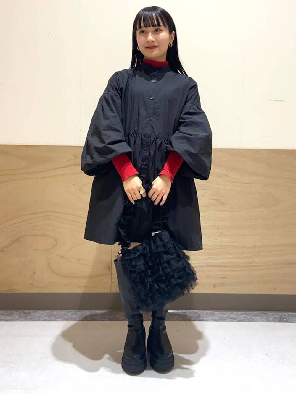 ブラック系のブーツ、ブラック系のワンピース、ブラック系のショルダーバッグを着用したレディースの冬コーディネートの2枚目の写真