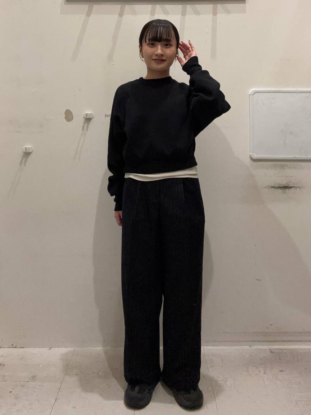 ブラック系のニット/セーター、ブルー系のその他パンツ、ホワイト系のキャミソールを着用したレディースの冬コーディネートの2枚目の写真