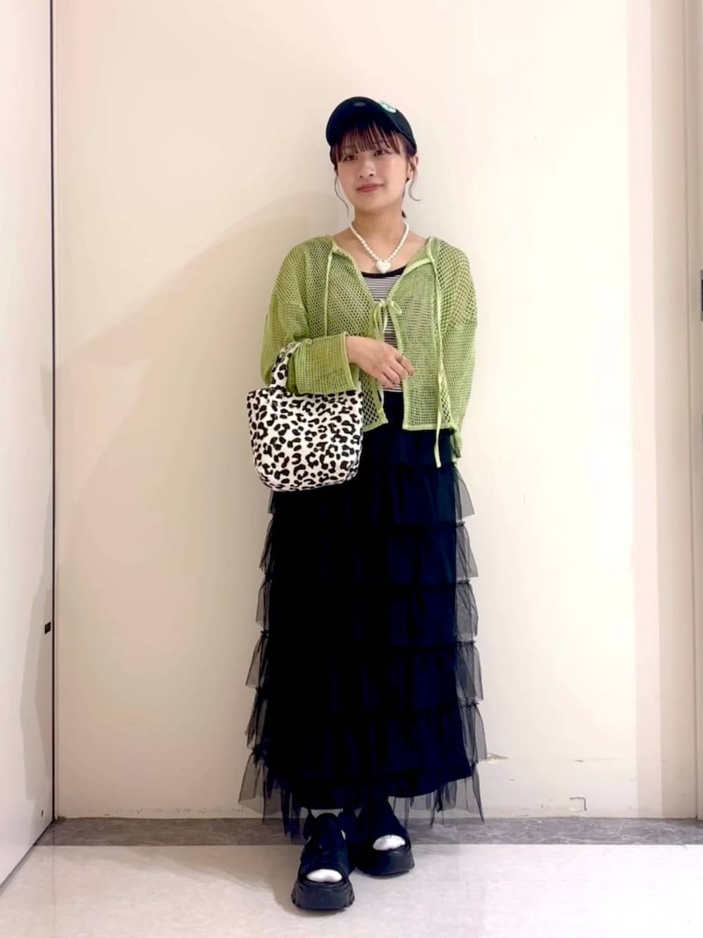 ブラック系のサンダル、グリーン系のニット/セーター、ブラック系のタンクトップを着用したレディースの春コーディネートの3枚目の写真