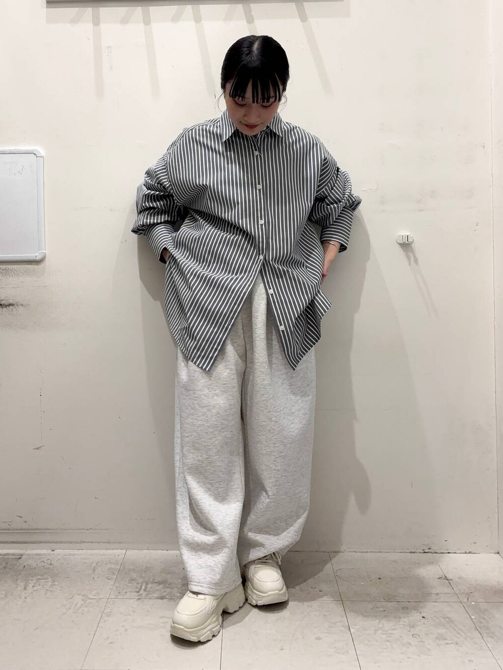 ブラック系のシャツ/ブラウス、グレー系のスウェットパンツ、ホワイト系のスニーカーを着用したレディースの春コーディネートの2枚目の写真