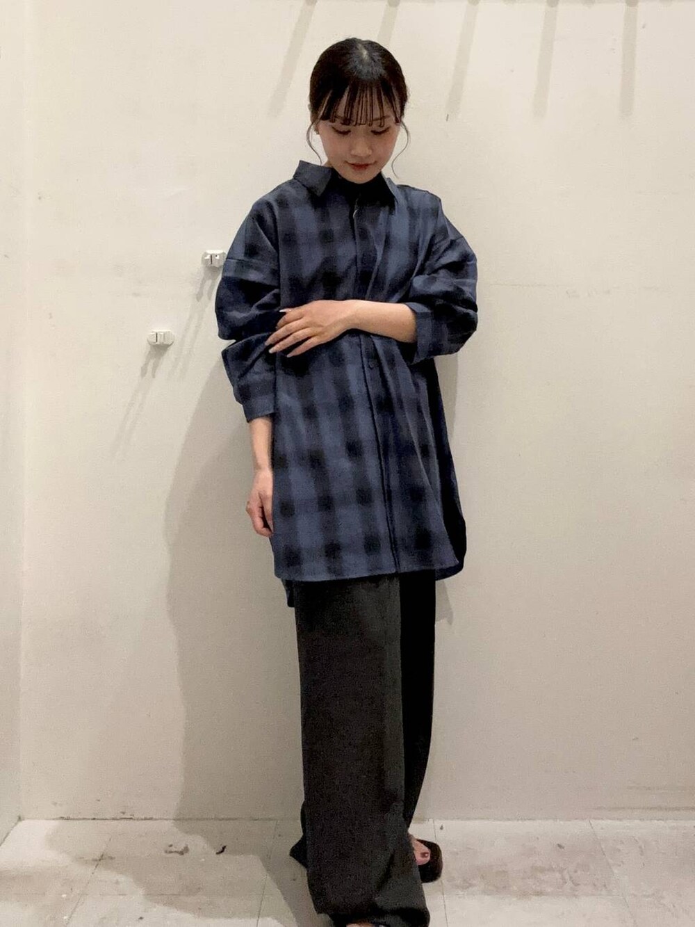 ブルー系のシャツ/ブラウス、ブラック系のスラックス、ブラック系のサンダルを着用したレディースの秋コーディネートの2枚目の写真