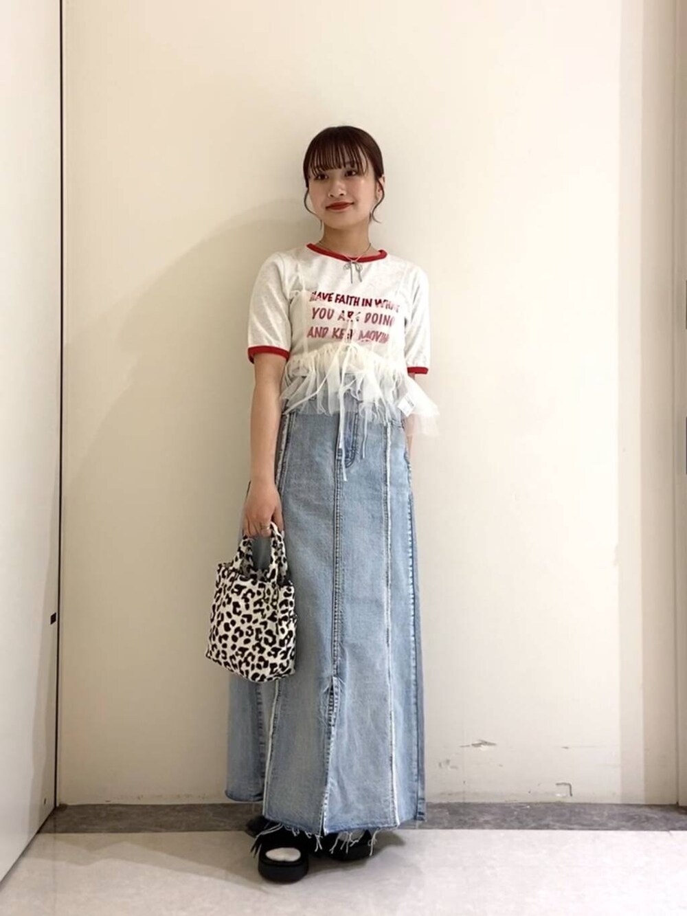 ブラック系のサンダル、ブラック系のトートバッグ、ブルー系のスカートを着用したレディースの春コーディネートの2枚目の写真