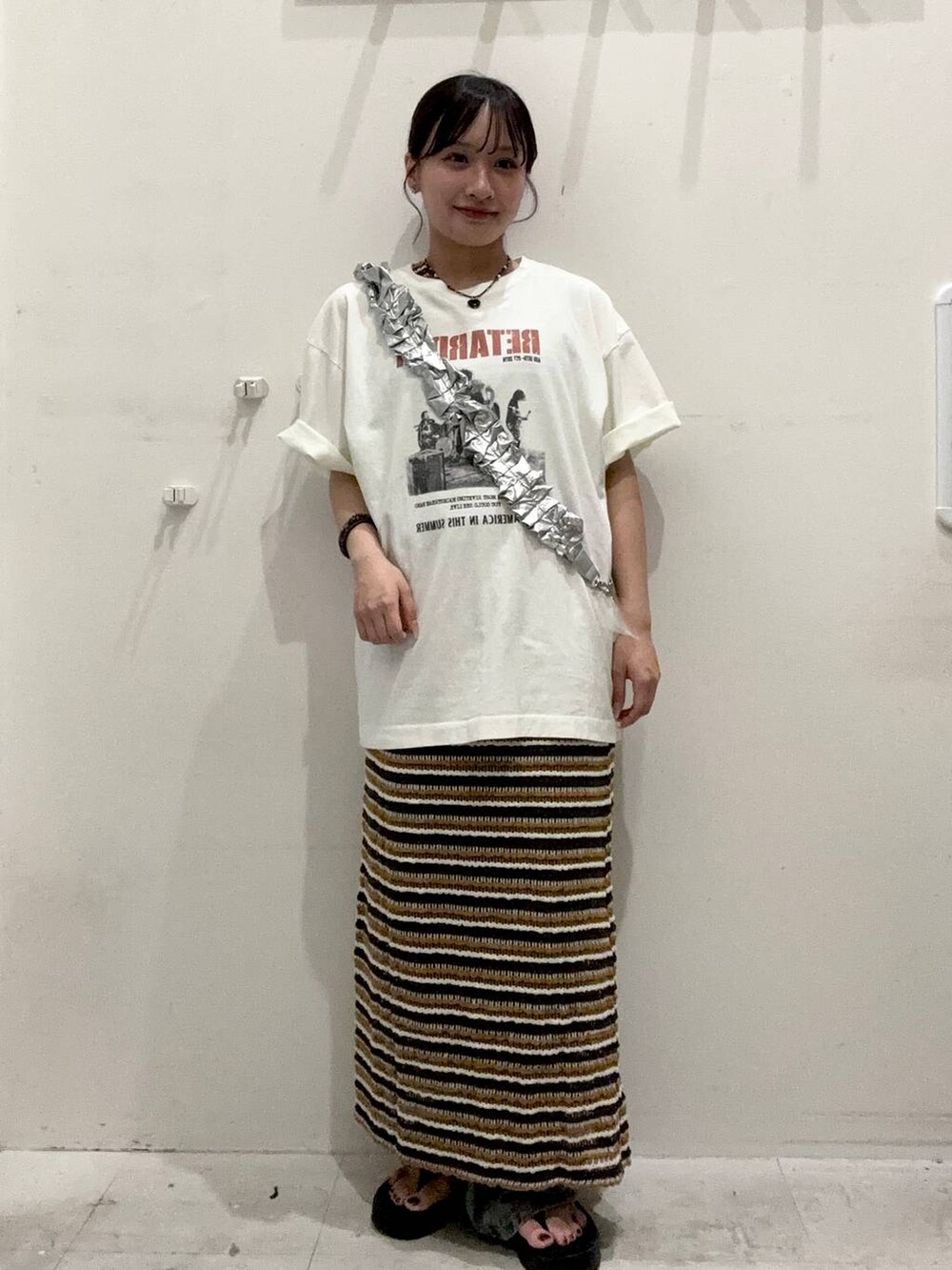 ブラック系のサンダル、ブルー系のデニムパンツ、ホワイト系のTシャツ/カットソーを着用したレディースの夏コーディネートの2枚目の写真