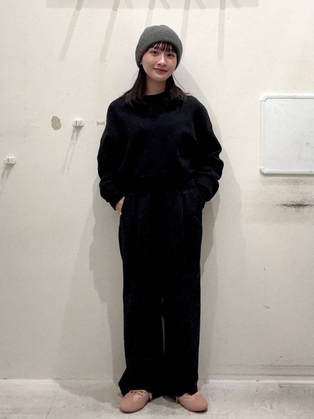 ブラック系のニット/セーター、ブルー系のその他パンツ、ピンク系のスニーカーを着用したレディースの冬コーディネートの2枚目の写真