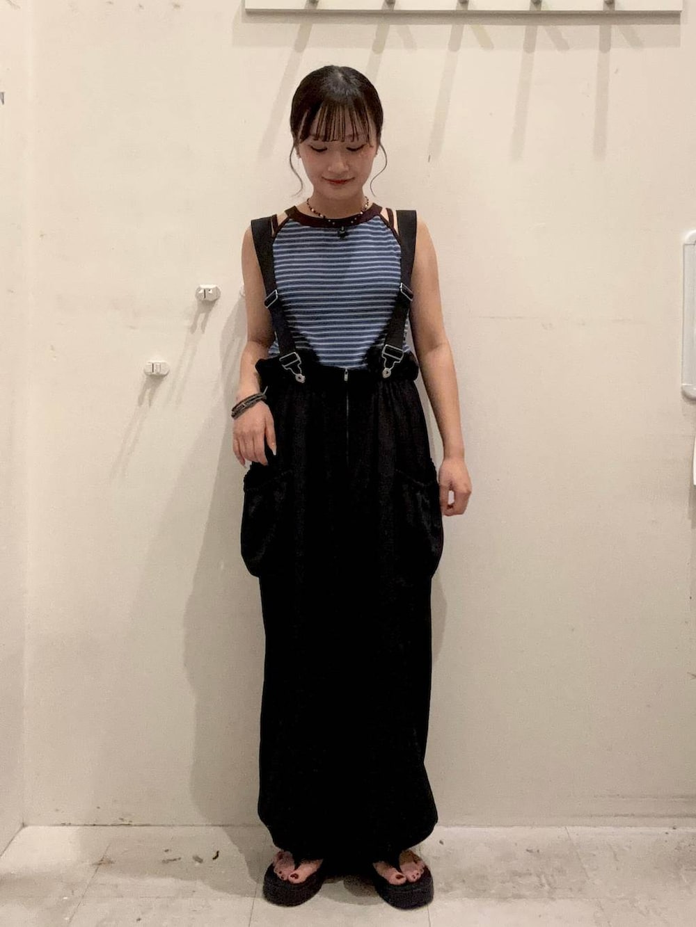 ブルー系のタンクトップ、ブラック系のワンピース、ブラック系のサンダルを着用したレディースの夏コーディネートの2枚目の写真