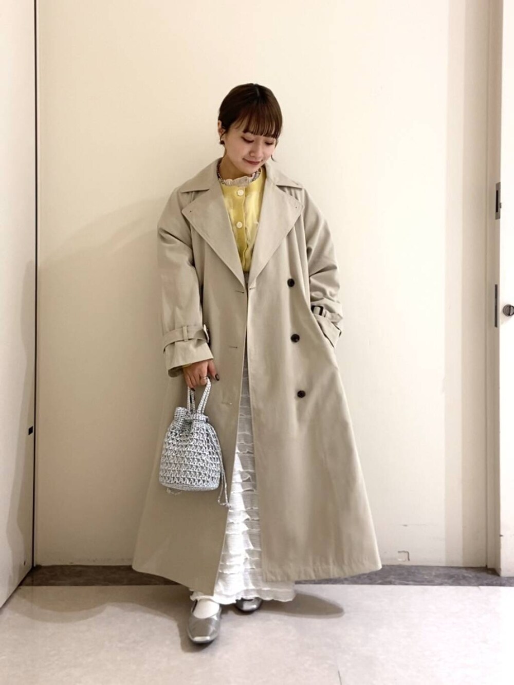 シルバー系のパンプス、ホワイト系のスカート、ホワイト系のTシャツ/カットソーを着用したレディースの春コーディネートの2枚目の写真