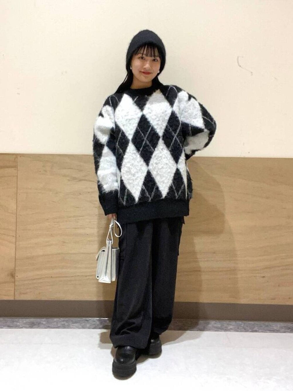 シルバー系のショルダーバッグ、ブラック系のカーゴパンツ、ブラック系のニット/セーターを着用したレディースの冬コーディネートの3枚目の写真