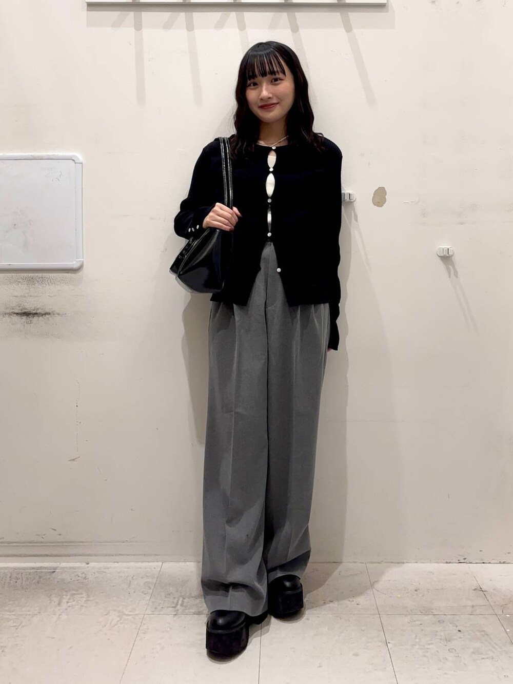 ブラック系のショルダーバッグ、グレー系のその他パンツ、ホワイト系のキャミソールを着用したレディースの冬コーディネートの2枚目の写真