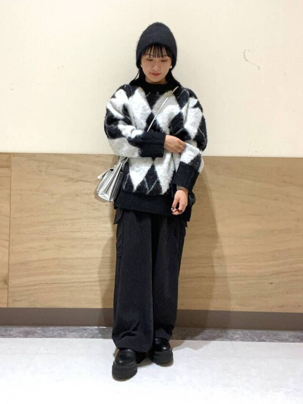 シルバー系のショルダーバッグ、ブラック系のカーゴパンツ、ブラック系のニット/セーターを着用したレディースの冬コーディネートの2枚目の写真