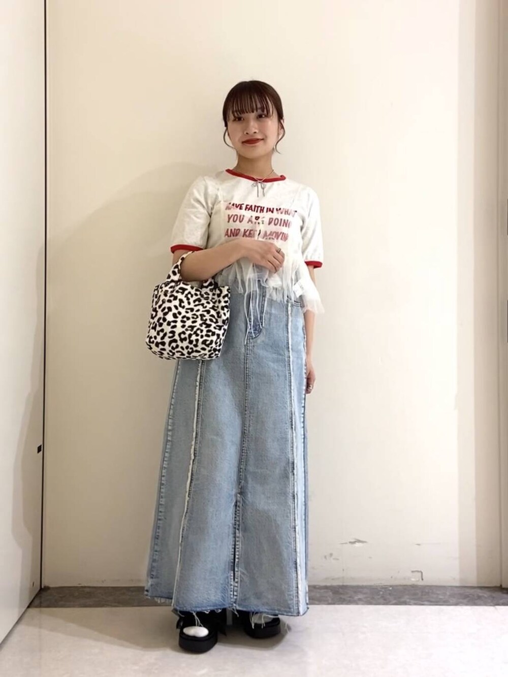 ブラック系のサンダル、ブラック系のトートバッグ、ブルー系のスカートを着用したレディースの春コーディネートの4枚目の写真