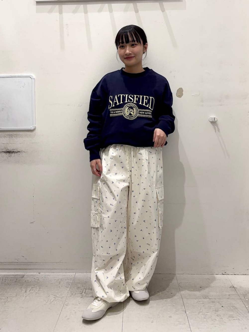 ブルー系のスウェット、ホワイト系のカーゴパンツ、ホワイト系のスニーカーを着用したレディースの春コーディネートの2枚目の写真